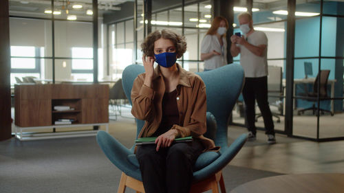 Young woman using mobile phone while sitting in gym