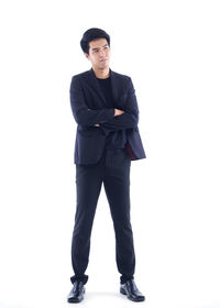 Portrait of young man standing against white background