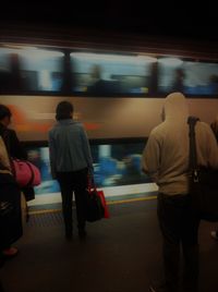 Rear view of people walking in train