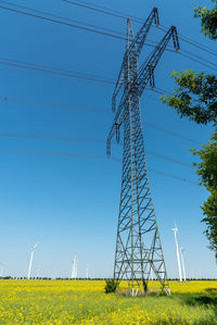 Electricity pole in a field of bloooming rapeseed seen in germany