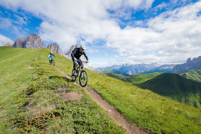 Bicycles riding bicycle on mountain against sky