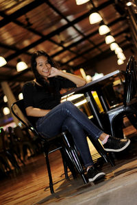 Portrait of young woman sitting on chair