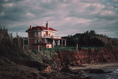 House by building against sky during sunset