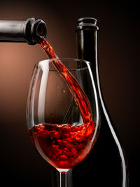 Close-up of wine glass bottle against black background