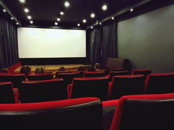 People sitting on red at movie theater