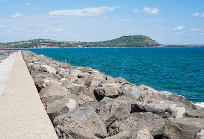 High angle view of rocky shore at sea against sky