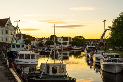 Boats moored at harbor during sunset