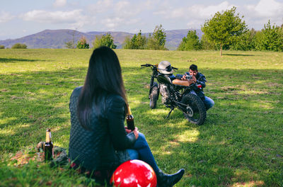 Man photographing woman sitting on land