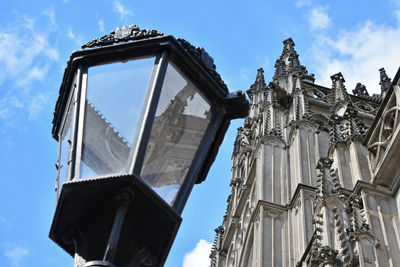 Low angle view of church and street light against sky