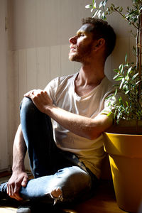 Side view of young woman sitting at home