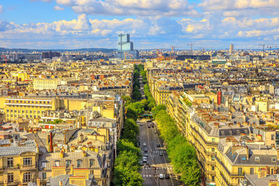 High angle view of city buildings against cloudy sky