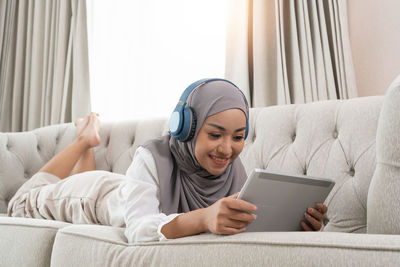 Portrait of young woman using digital tablet at home