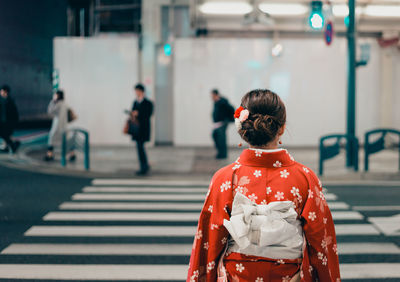 Rear view of woman standing on street