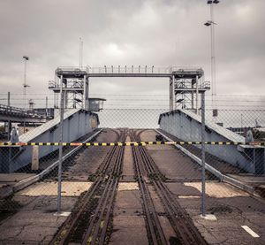 Railroad tracks against cloudy sky