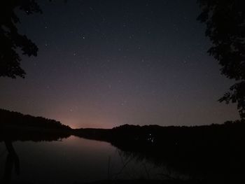 Scenic view of lake against sky at night