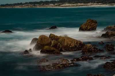 Rocks on beach against sky