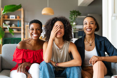 Portrait of smiling friends sitting at home