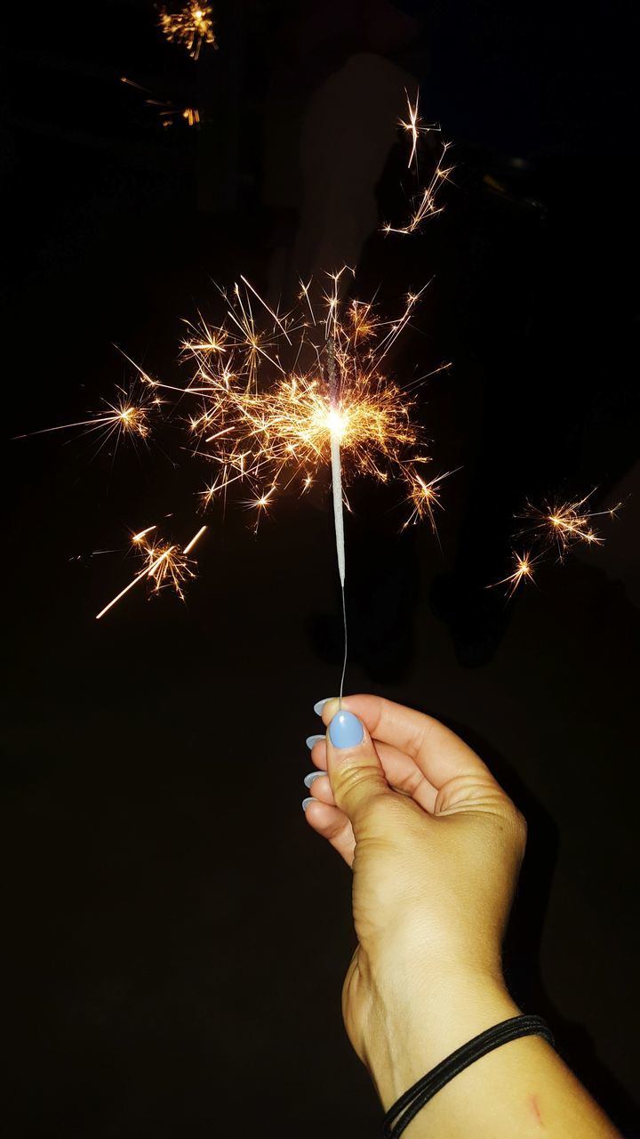 CROPPED IMAGE OF HAND HOLDING ILLUMINATED FIREWORKS