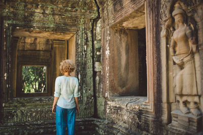 Rear view of woman standing at historical building