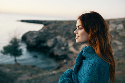 Beautiful woman standing at beach during sunset