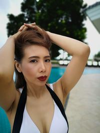 Portrait of woman with hand in hair in swimming pool