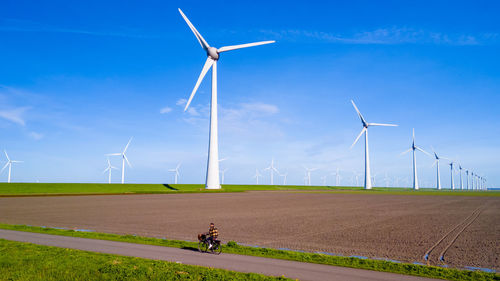 Windmills on field against clear sky