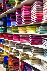 Full frame shot of multi colored rolled up fabrics for sale on shelves