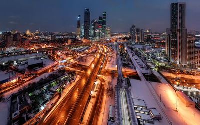 High angle view of illuminated city street and buildings at night