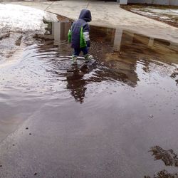 Reflection of people in puddle