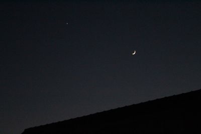 Low angle view of silhouette moon against clear sky at night