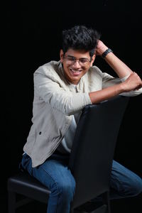 Joyful attitude of man sitting on  black chair