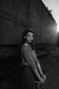 Portrait of woman standing against built structure