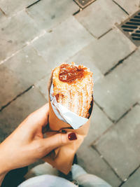 High angle view of person holding ice cream on footpath