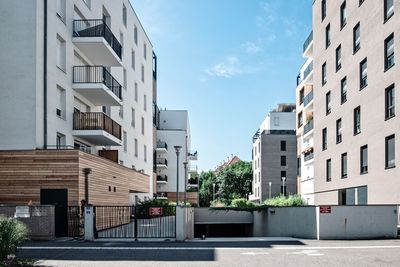 Residential buildings by road against sky