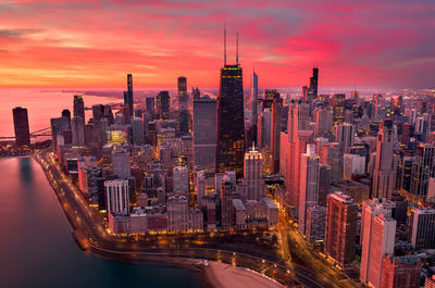 Aerial view of buildings in city during sunset