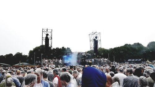 Crowd at music concert against clear sky