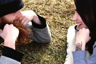 Midsection of smiling young woman lying on grass