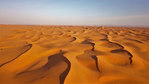 Sand dunes in desert against sky