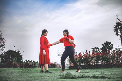 Beautiful two chubby teens exercise with muay thai or thai boxing in red clothes against covid 19