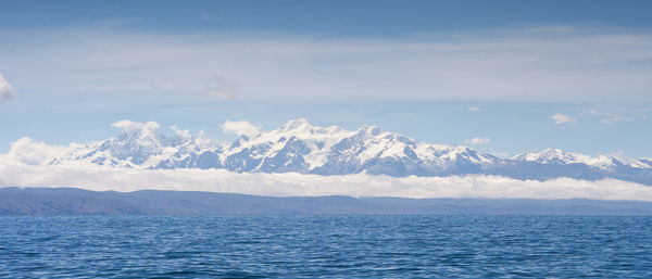 Scenic view of sea and mountains against sky