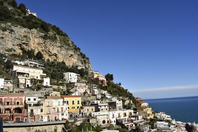 Townscape by sea against clear sky