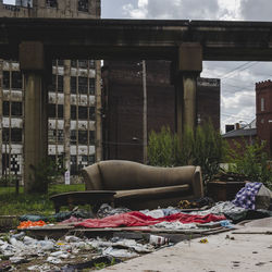 Old damaged sofa against abandoned building