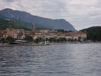 Houses by lake against sky