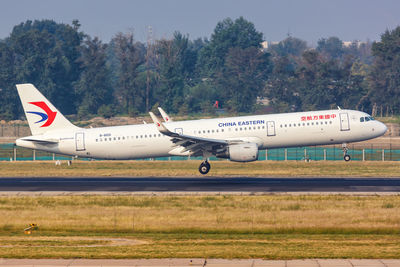 Airplane on airport runway against sky