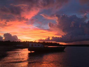 Scenic view of sea against dramatic sky during sunset