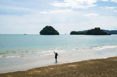 Man standing on beach against sky