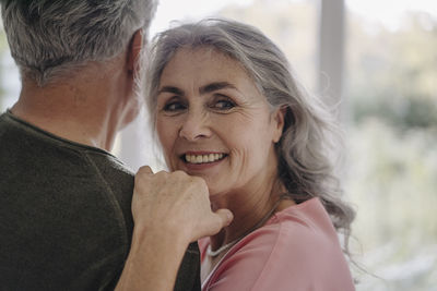 Portrait of smiling mature woman with her husband at home