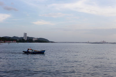 Boat sailing in sea against sky