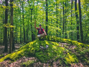 Man standing amidst plants in forest