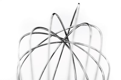 Close-up of wire whisk against white background